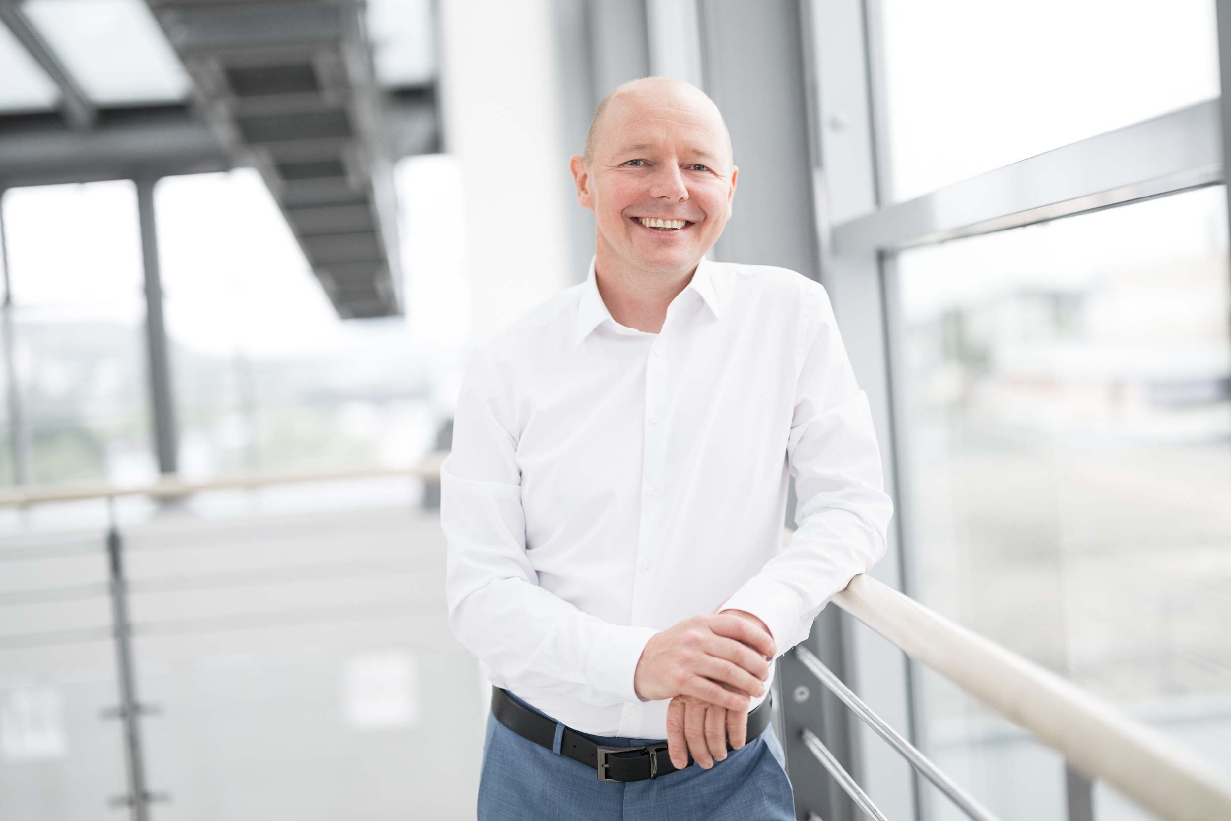 Jan Buschmeyer in a white shirt in a light-filled atrium